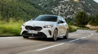 Novo BMW M135 2026 em movimento na pista com destaque para o design fluido e novos faróis
