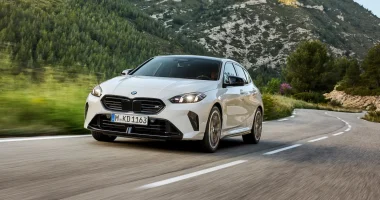 Novo BMW M135 2026 em movimento na pista com destaque para o design fluido e novos faróis