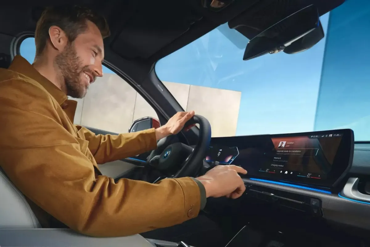 Interior de veículo BMW mostrando smartphone com chave digital próximo ao volante