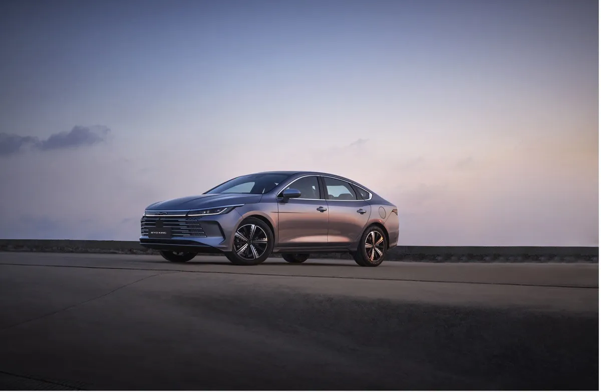 Foto do sedã híbrido BYD King GL em movimento em ambiente urbano