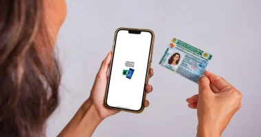 Smartphone exibindo aplicativo da CNH Digital com fundo de trânsito desfocado