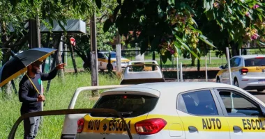 Carro de autoescola realizando estacionamento lateral simples sem baliza entre veículos