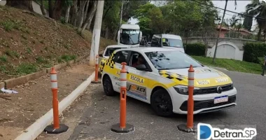 Carro de autoescola realizando manobra de estacionamento próximo ao meio-fio sob supervisão de instrutor.