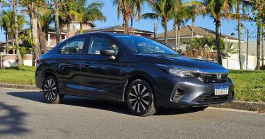 Casal feliz recebendo chaves de carro novo em concessionária Honda.