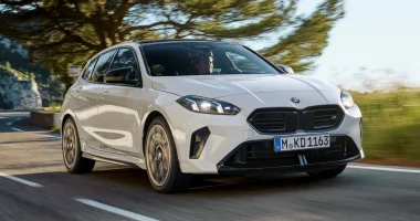 Foto do novo BMW M135 xDrive mostrando a frente e lateral do veículo em uma pista.