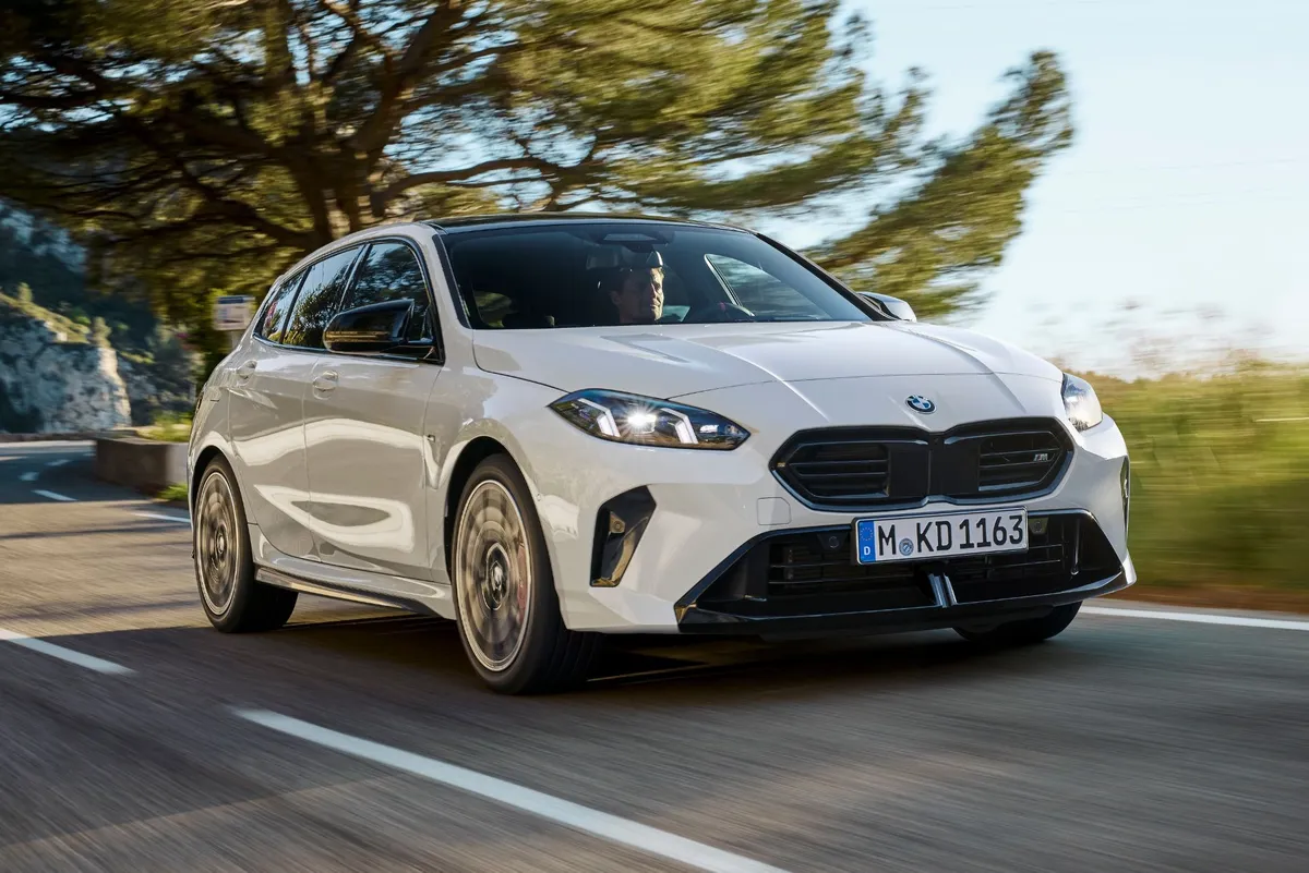 Foto do novo BMW M135 xDrive mostrando a frente e lateral do veículo em uma pista.