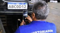 Mecânico realiza inspeção em motor de carro usado em centro de vistoria
