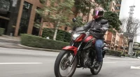 Trânsito urbano movimentado com destaque para motocicletas Honda e entregadores, ilustrando o recorde de vendas em 2025