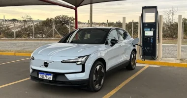 Volvo EX30 conectado a um carregador em ambiente interno sob luz artificial.