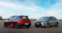 Carro compacto branco transitando em rodovia ensolarada representando eficiência energética