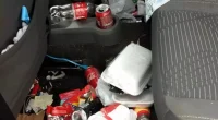 Interior de veículo com acúmulo excessivo de lixo e embalagens no banco do passageiro